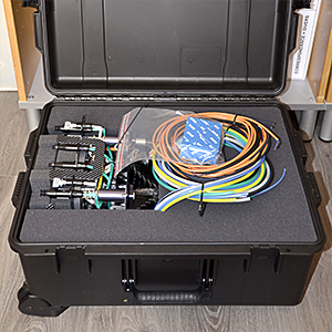 A picture of an open transport hardcase with a carbon fiber composite robot gripper nested in protective foam